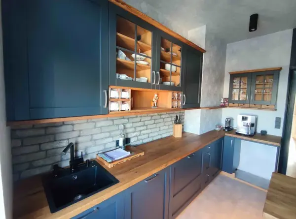 Moderne Küche mit blauen Schränken, Holzarbeitsplatte und Spüle