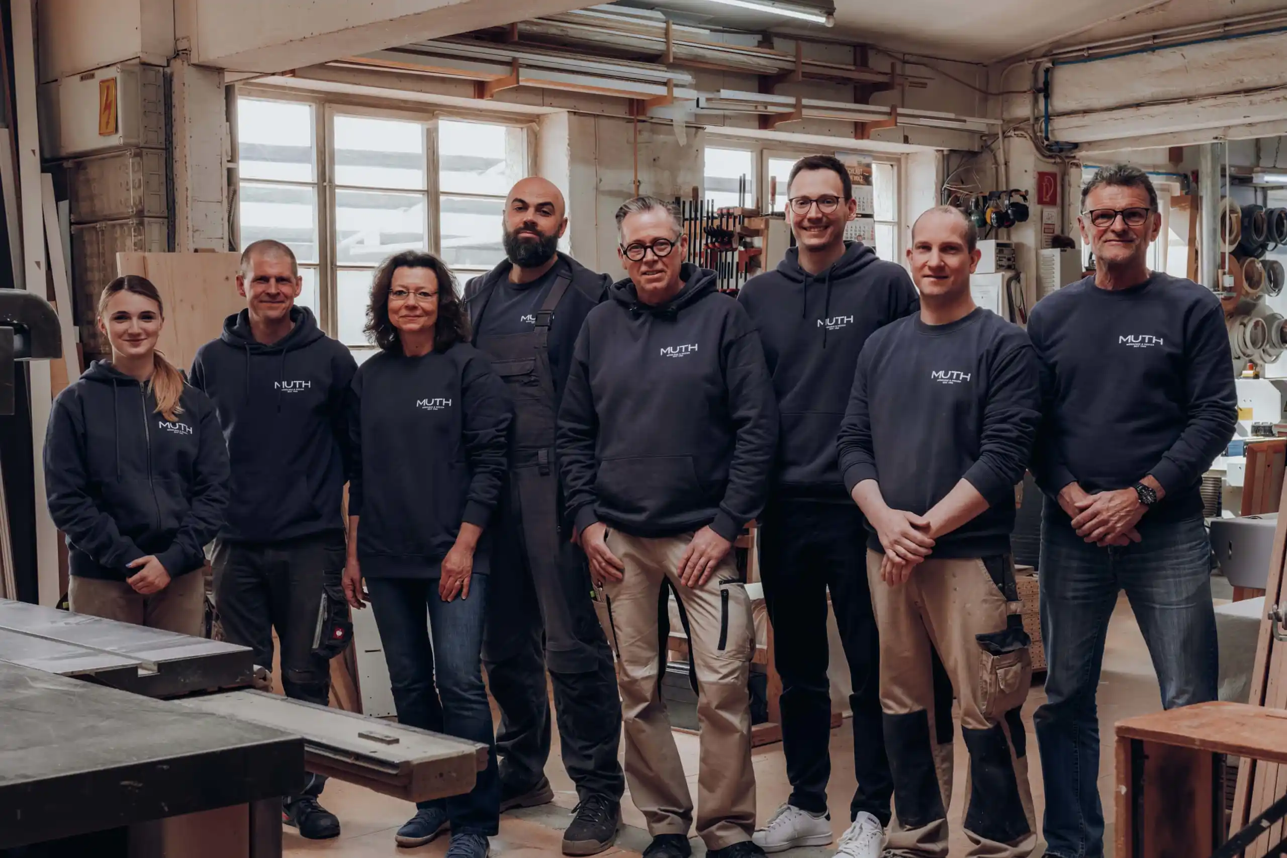 Team von Schreinerei MUTH in Werkstatt, Gruppenfoto mit Arbeitskleidung